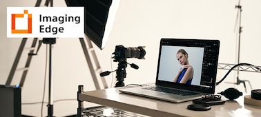 Image of studio illustrating Imaging Edge PC application, with camera on tripod, and PC with camera image on screen