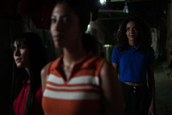 Example image of three women in the dark with the furthest from the camera in sharp focus