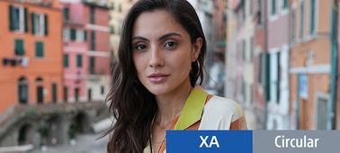 Example portrait image of a woman in focus with a wide angle background in depth with bokeh, showing that both wide angle and bokeh expressions can be achieved.